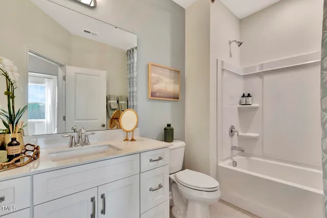 a bathroom with a toilet a sink a mirror a bathtub and vanity