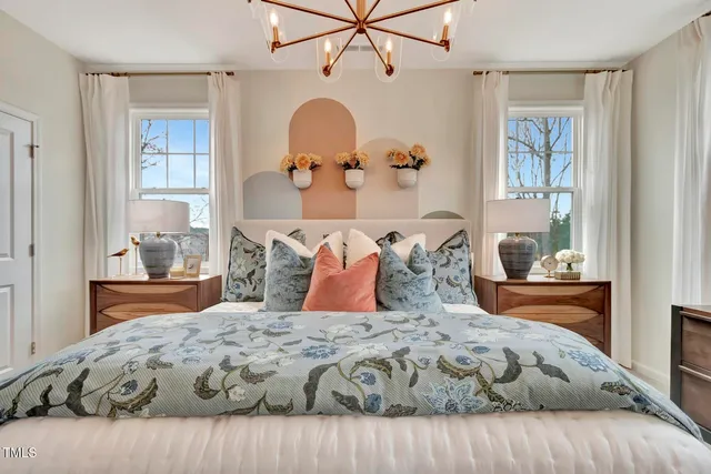 a bedroom with a large bed and a chandelier