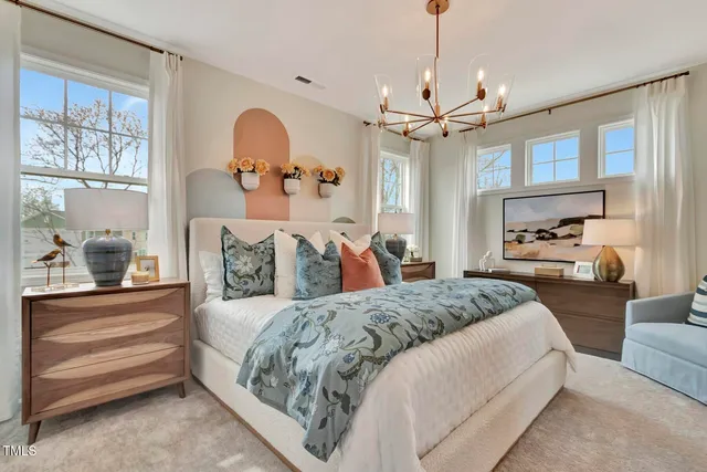a spacious bedroom with a large bed and a chandelier