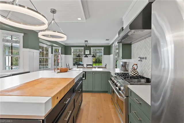a kitchen with stainless steel appliances granite countertop sink stove and wooden floor