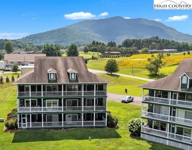 a view of a house with a big yard plants and large trees