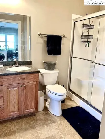 a bathroom with a granite countertop toilet sink and mirror