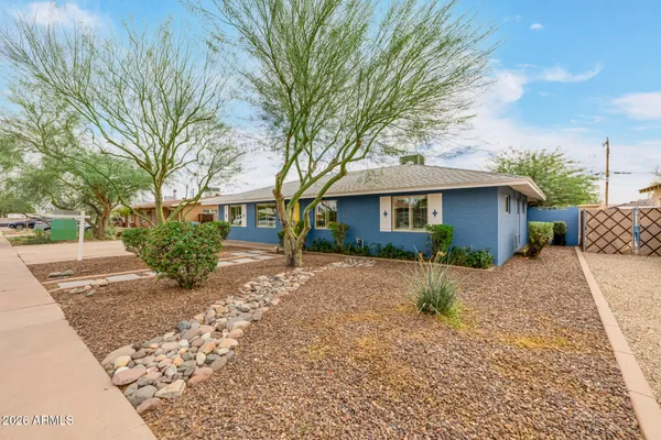 a front view of house with yard and trees around