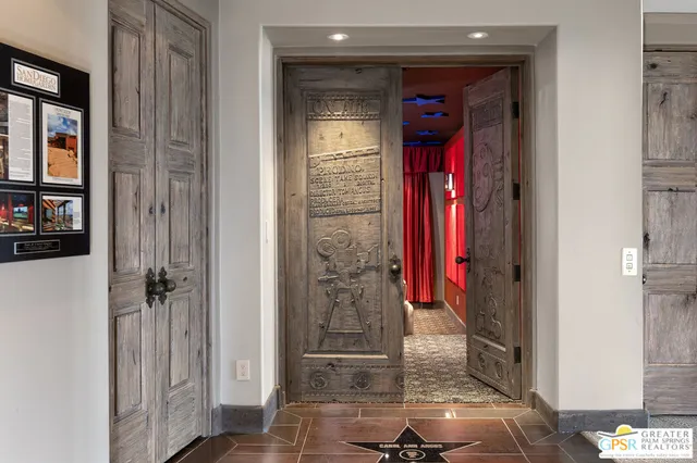 a spacious bedroom with a balcony a large bed and a chandelier