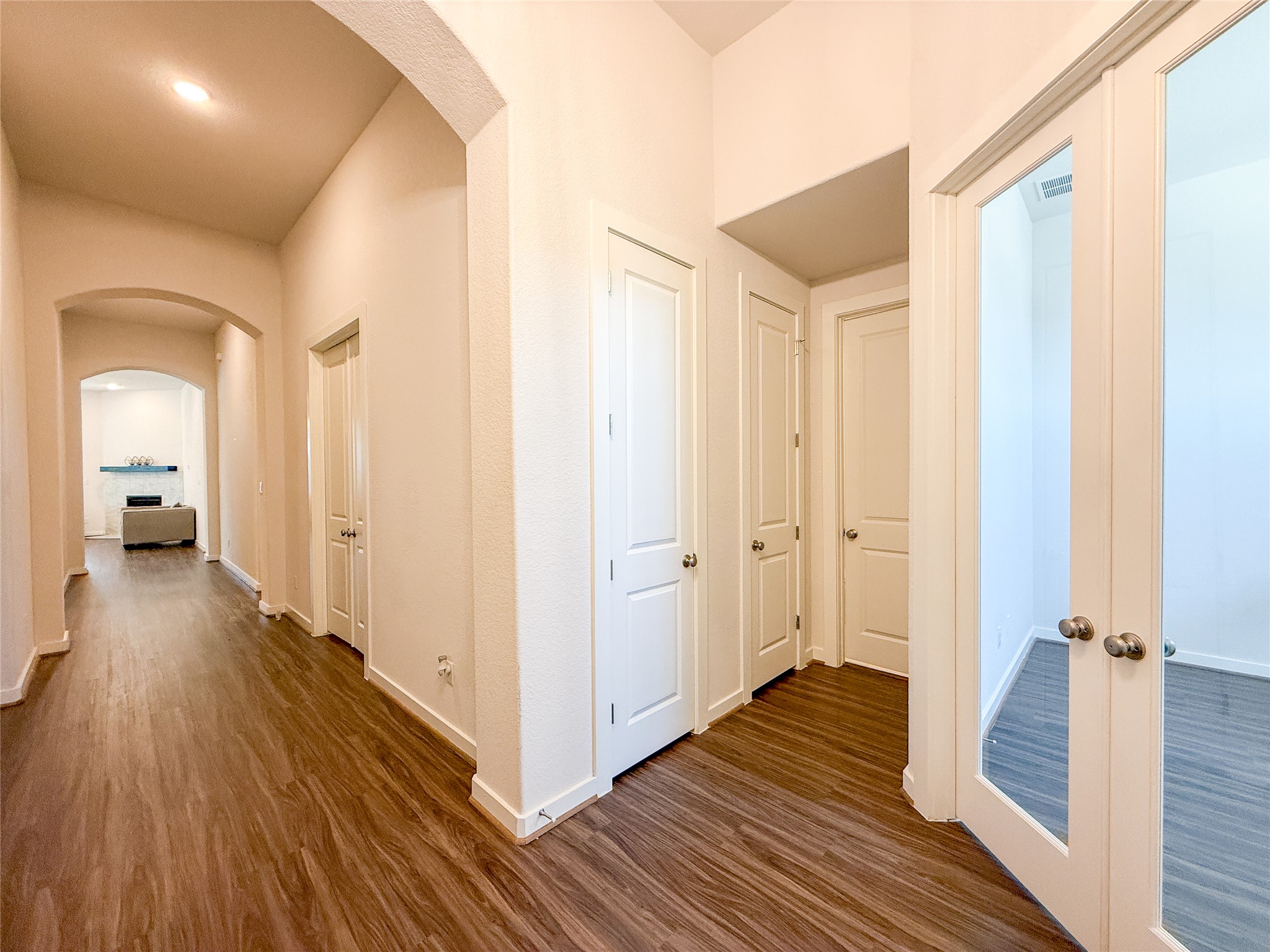 249 Heartleaf Road San Marcos, TX 78666 - Photo 4 of 38 A spacious central hallway with rich wood-look flooring connects various rooms within the home.
