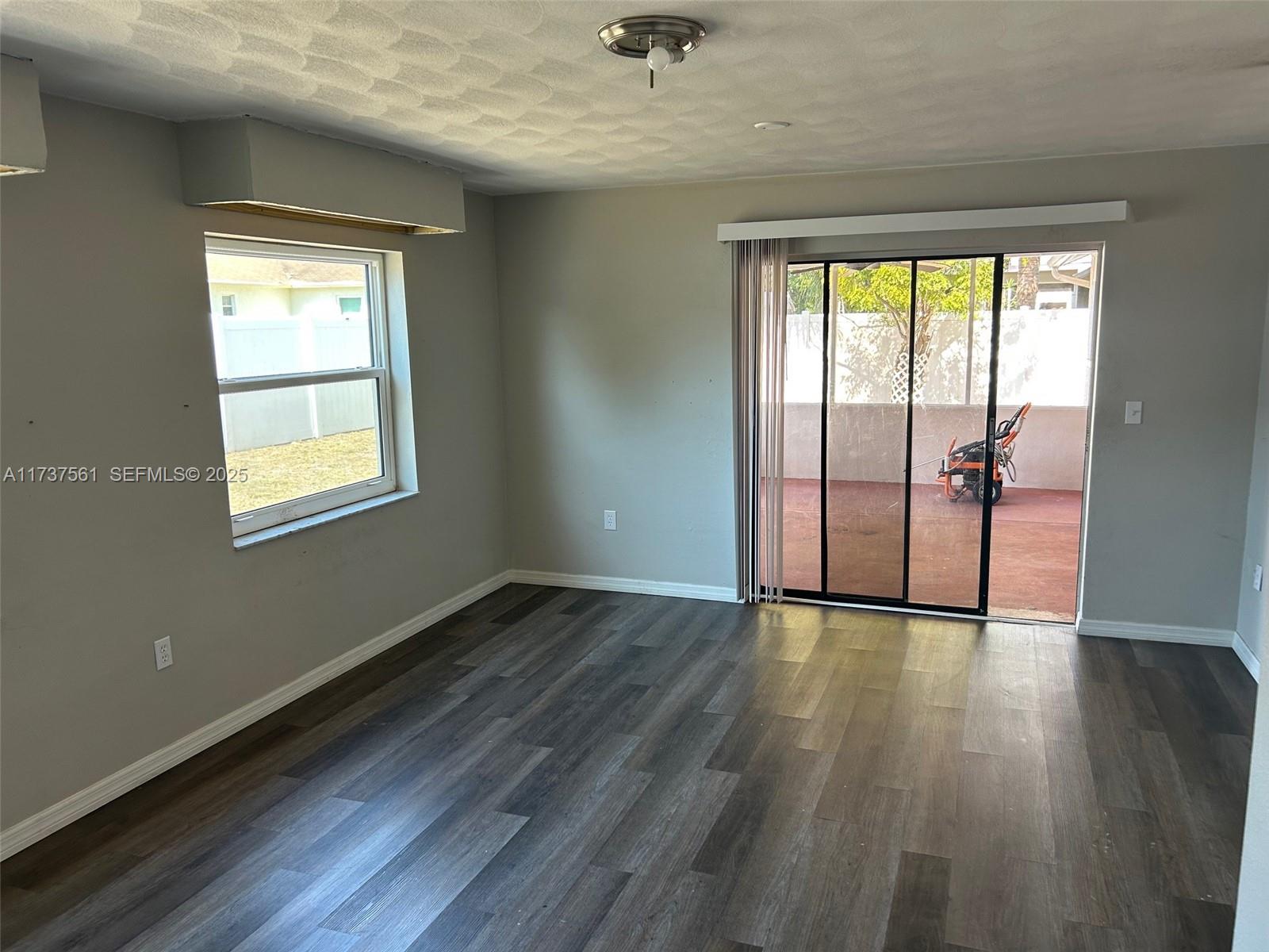 7403 Foxbloom Drive Port Richey, FL 34668 - Photo 21 of 45 an empty room with wooden floor and windows