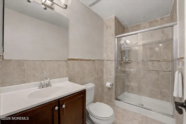 a bathroom with a sink a toilet and shower