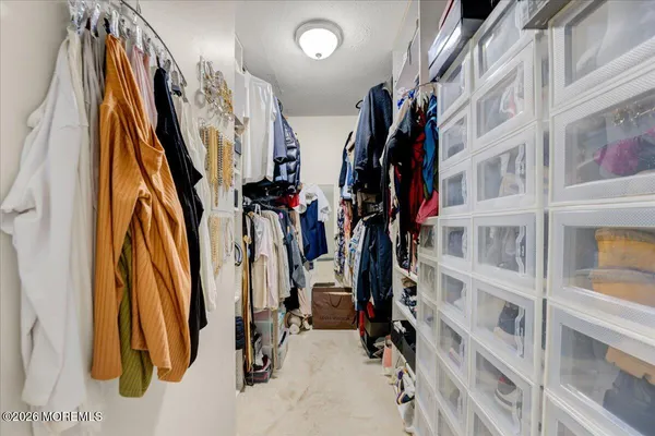 a view of walk in closet with clothes