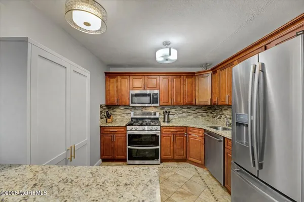 a kitchen with stainless steel appliances granite countertop a stove top oven a sink and dishwasher