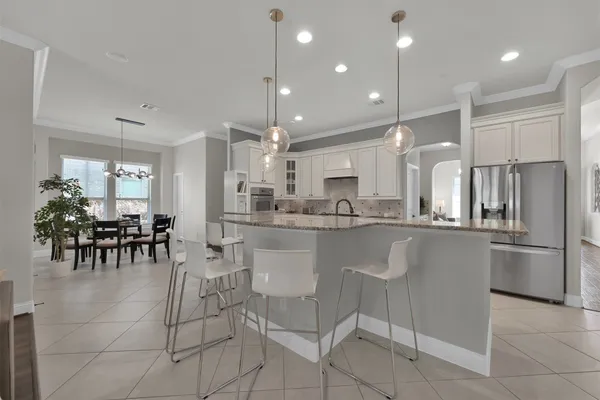 a kitchen with stainless steel appliances kitchen island granite countertop a refrigerator and cabinets