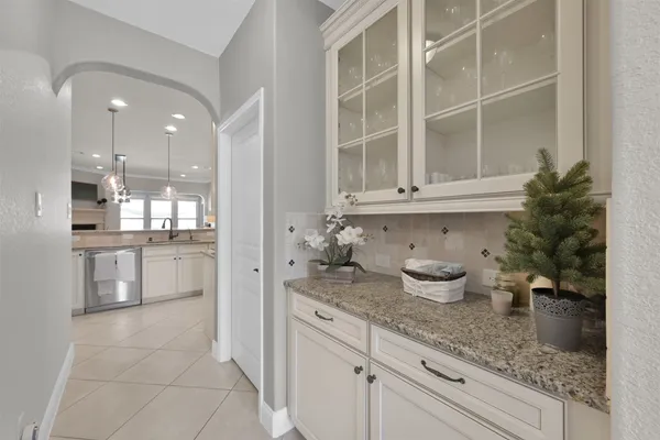 a kitchen with a refrigerator and white cabinets
