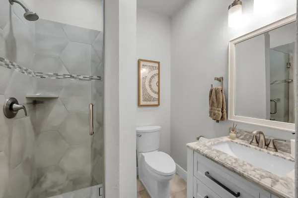 a bathroom with a granite countertop sink toilet and shower