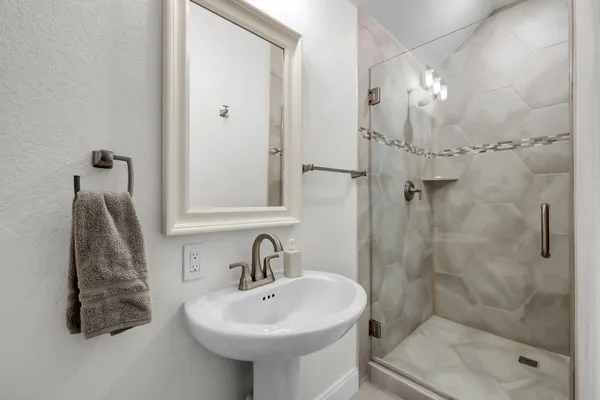 a bathroom with a sink a toilet and shower