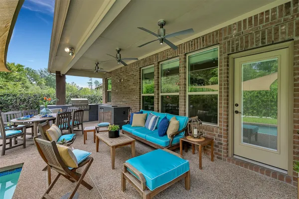 a roof deck with table and chairs and potted plants