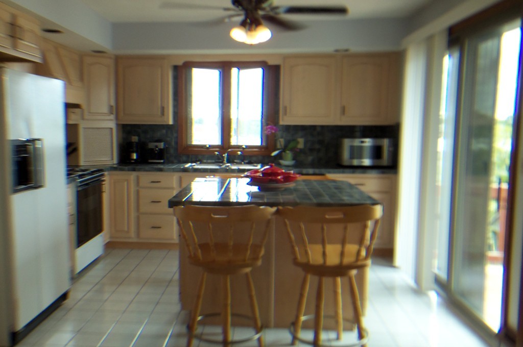 111 Anthony Fall River Fall River, MA 02721 - Photo 4 of 19 a kitchen with stainless steel appliances granite countertop a stove a refrigerator a sink a dining table and chairs with wooden floor