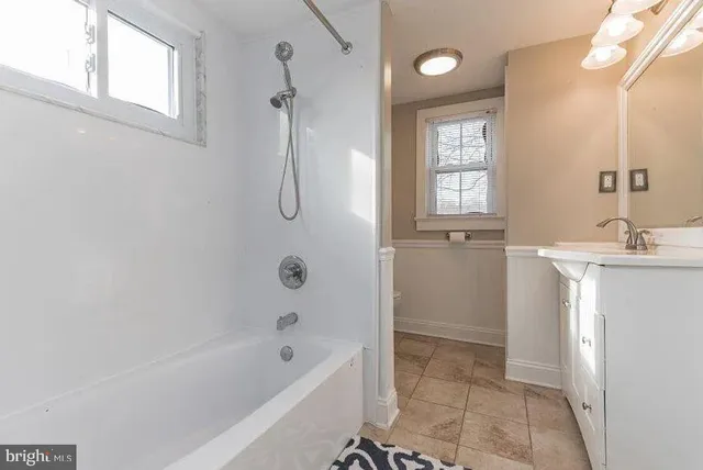 a bathroom with a bathtub a shower a sink and a window