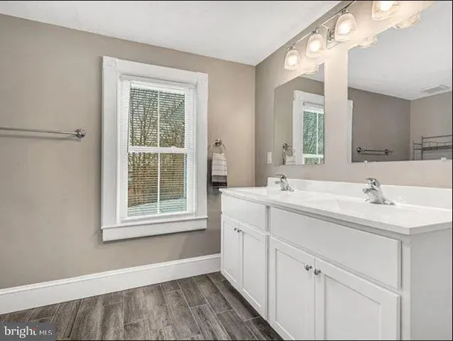 a bathroom with a sink mirror and a window