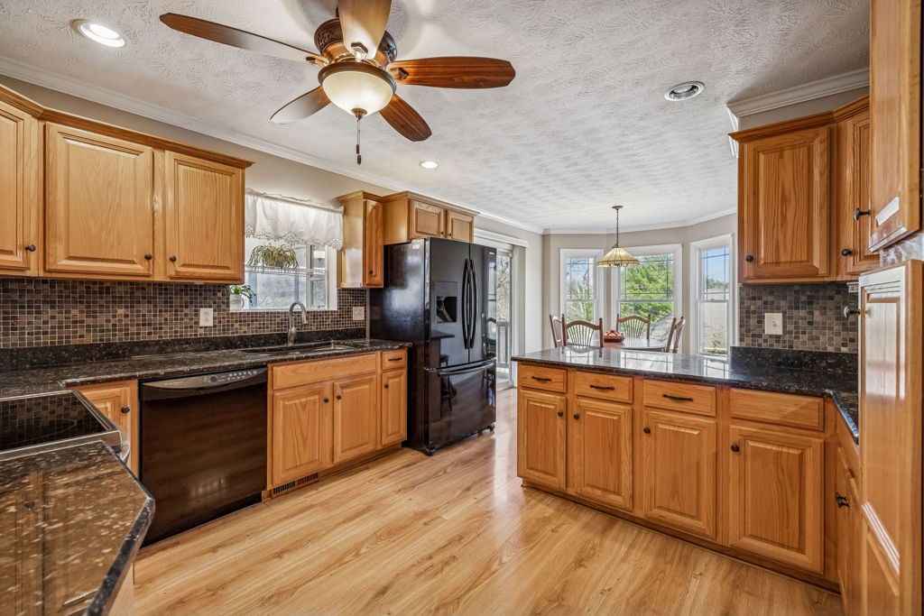 1728 Riverhaven Drive Adams, TN 37010 - Photo 22 of 75 a kitchen with granite countertop wooden floors white cabinets and stainless steel appliances
