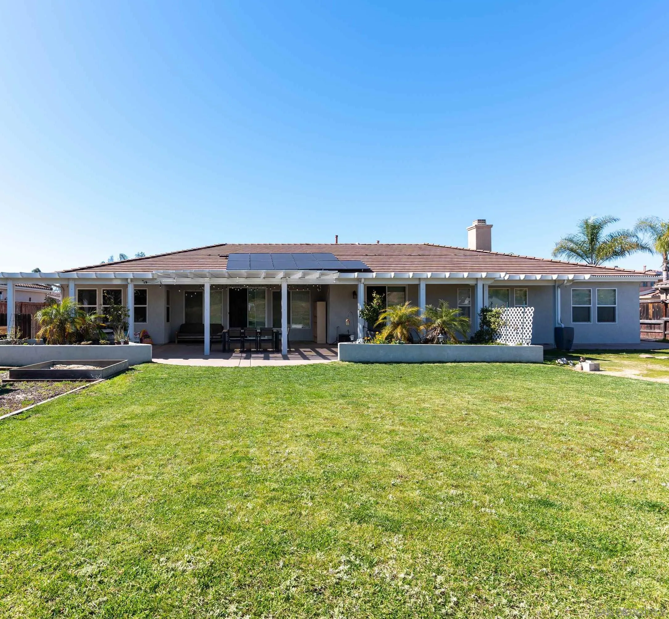 a front view of house with yard barbeque and outdoor seating