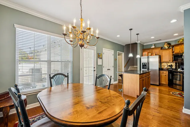a kitchen with stainless steel appliances granite countertop a kitchen island a table and chairs in it