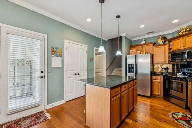 a kitchen with stainless steel appliances granite countertop a stove refrigerator and cabinets