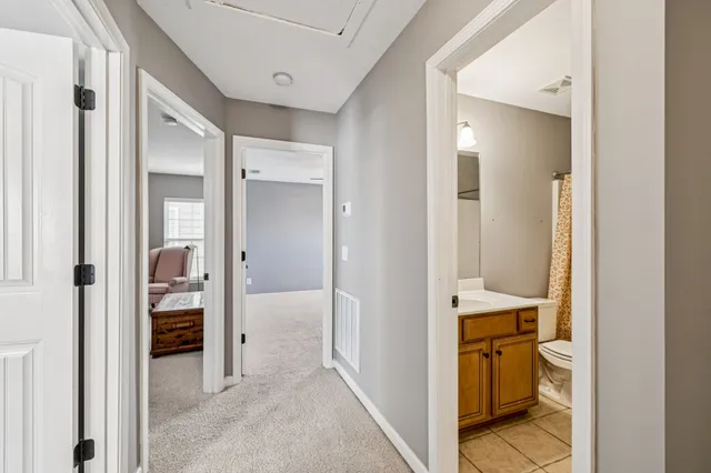 an empty room with windows and chandelier fan