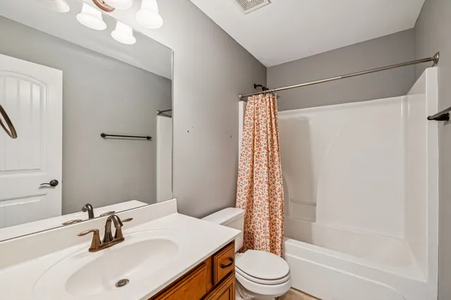 an empty room with a chandelier fan and closet