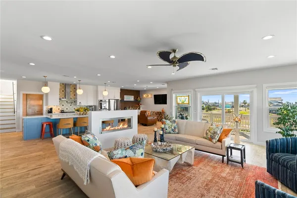 a kitchen with stainless steel appliances kitchen island granite countertop a dining table chairs and a refrigerator