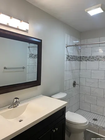 a bathroom with a sink a toilet and shower