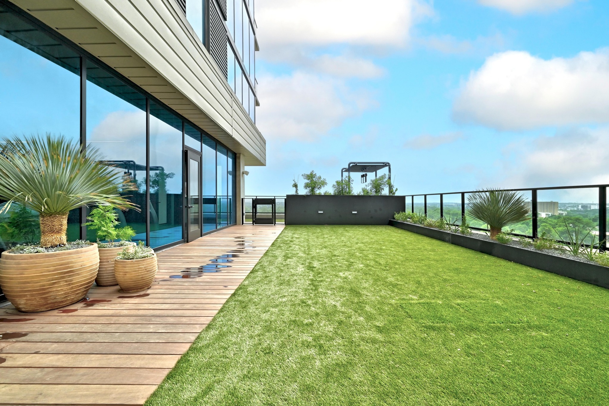 84 East Avenue, Unit 2008 Austin, TX 78701 - Photo 8 of 23 An inviting rooftop terrace with artificial turf and wooden decking offers sweeping outdoor views.