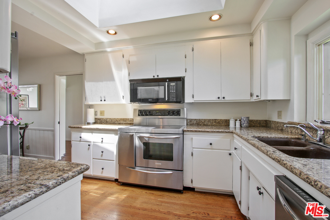 201 Tranquillo Road Pacific Palisades, CA 90272 - Photo 9 of 19 a kitchen with granite countertop a sink stainless steel appliances and white cabinets