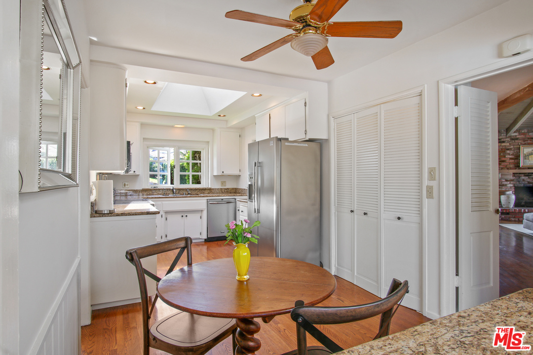 201 Tranquillo Road Pacific Palisades, CA 90272 - Photo 10 of 19 a kitchen with stainless steel appliances kitchen island granite countertop a dining table chairs and a refrigerator