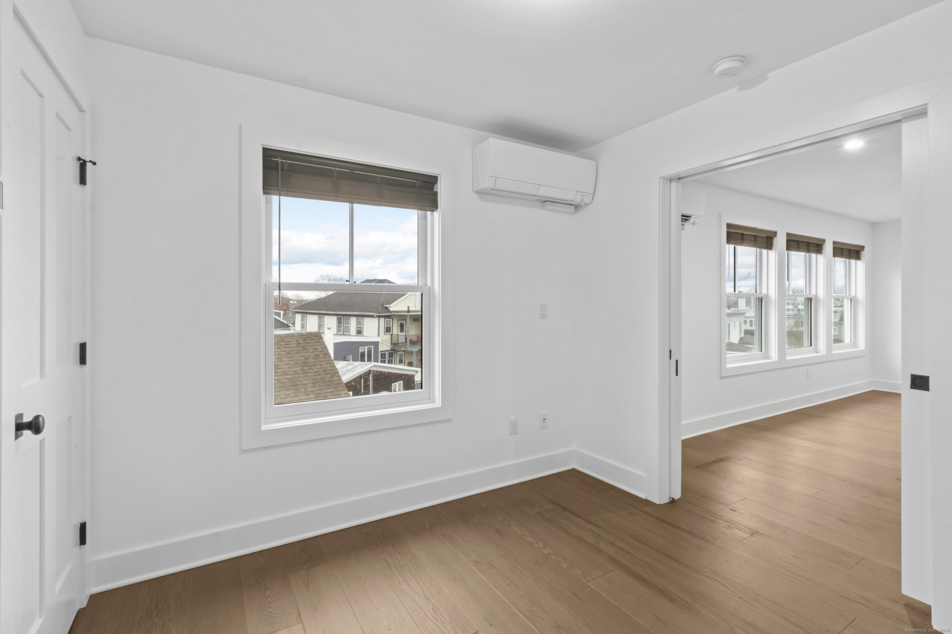 3 Water Street, Unit 305 Groton, CT 06355 - Photo 9 of 20 an empty room with wooden floor and windows