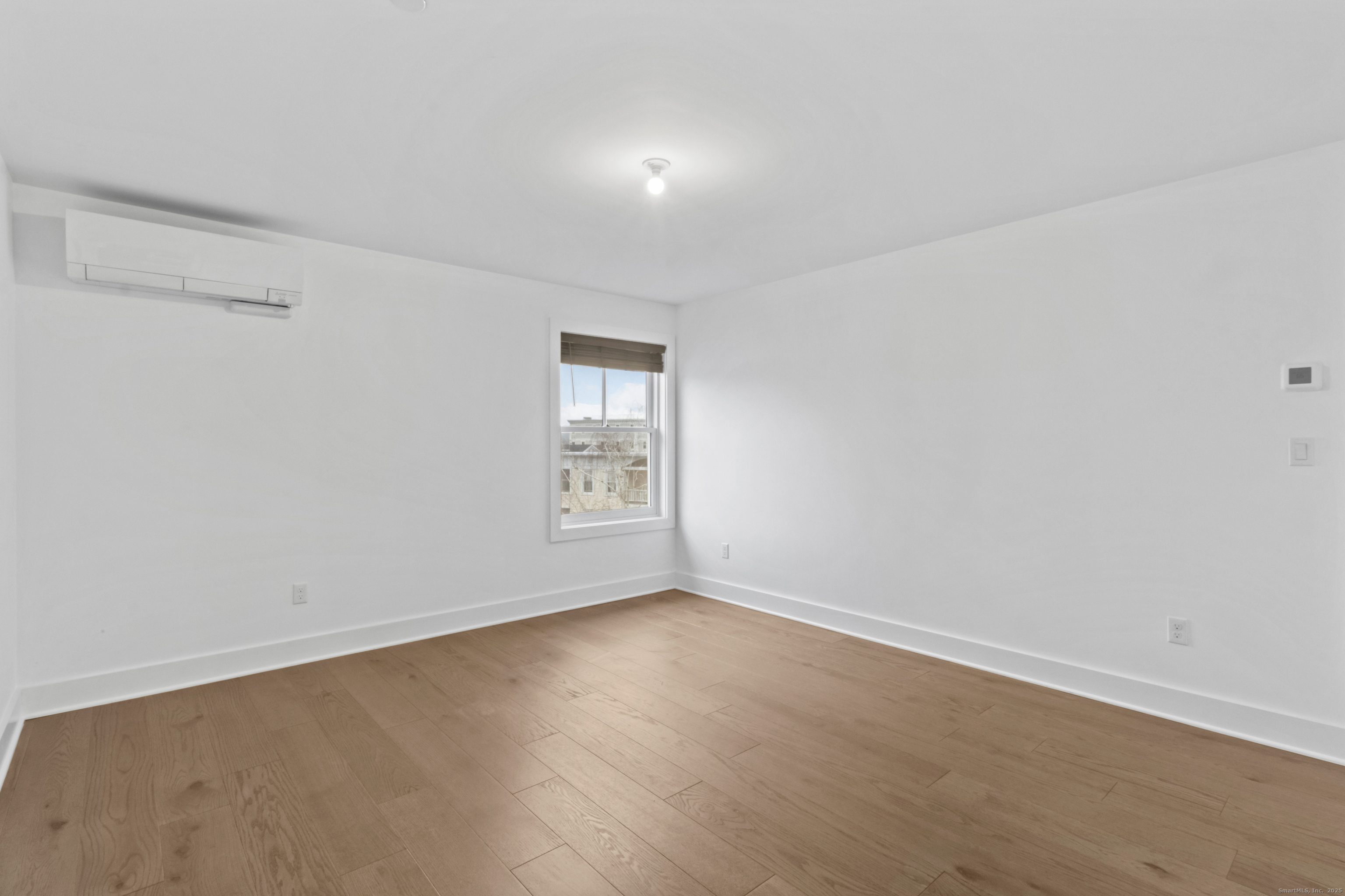 3 Water Street, Unit 305 Groton, CT 06355 - Photo 10 of 20 a view of an empty room with wooden floor and a window