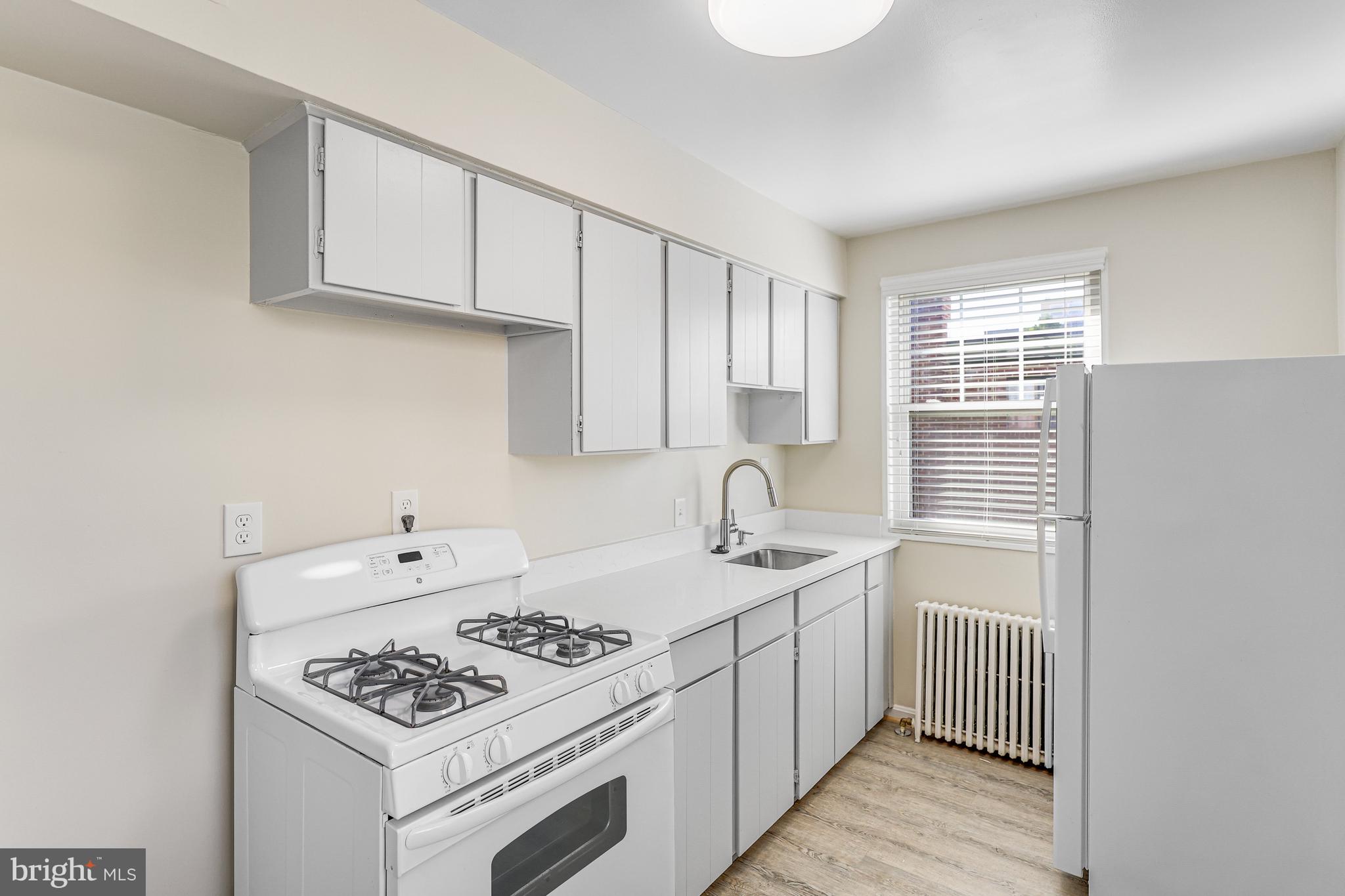 1404 12th Street North, Unit 32 Arlington, VA 22209 - Photo 12 of 26 a kitchen with stainless steel appliances granite countertop a sink stove and cabinets