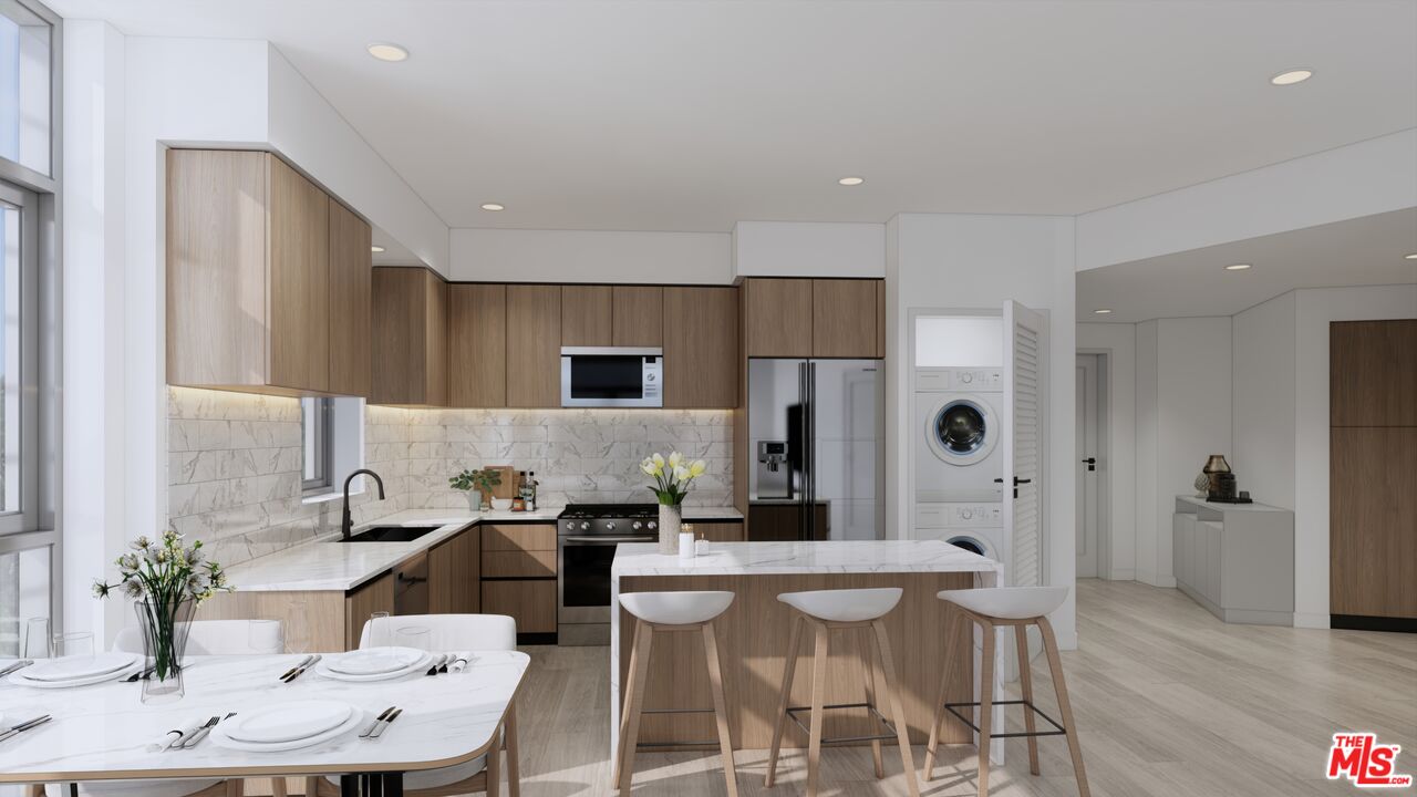 160 Chestnut Street, Unit 204 Pasadena, CA 91103 - Photo 2 of 22 a kitchen with stainless steel appliances kitchen island granite countertop a refrigerator and a dining table