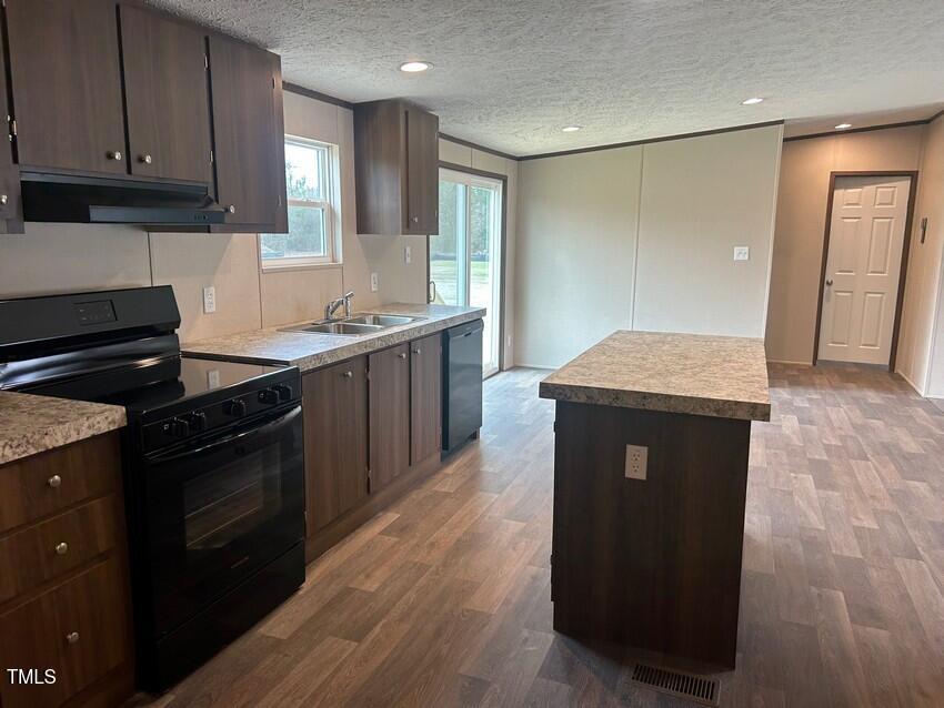 3356 North McCullen Road Faison, NC 28341 - Photo 11 of 25 a kitchen with stainless steel appliances granite countertop a stove a sink and a refrigerator