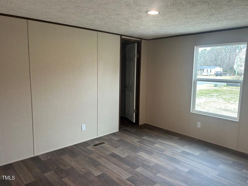 3356 North McCullen Road Faison, NC 28341 - Photo 22 of 25 an empty room with wooden floor and windows
