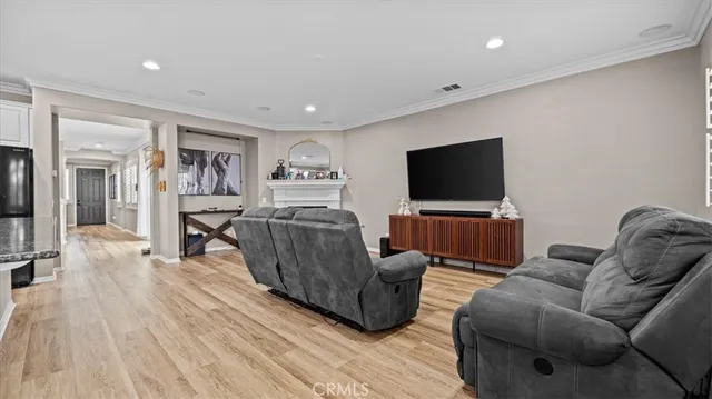 a kitchen with stainless steel appliances granite countertop a sink dishwasher a refrigerator and white cabinets with wooden floor