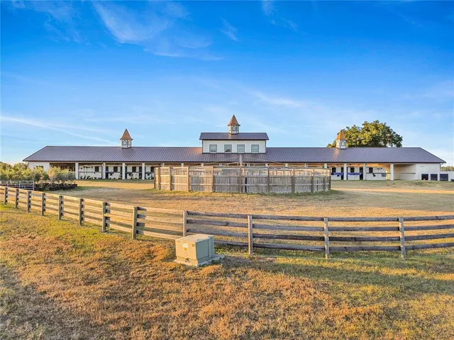 a view of a swimming pool with lawn chairs and plants