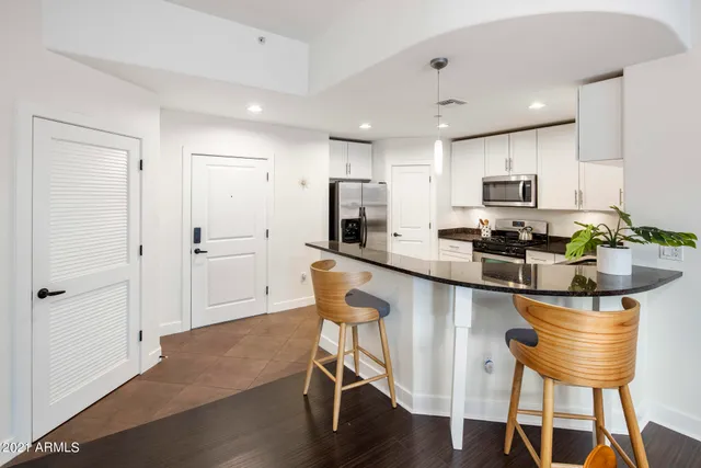 a kitchen with a table chairs refrigerator and microwave
