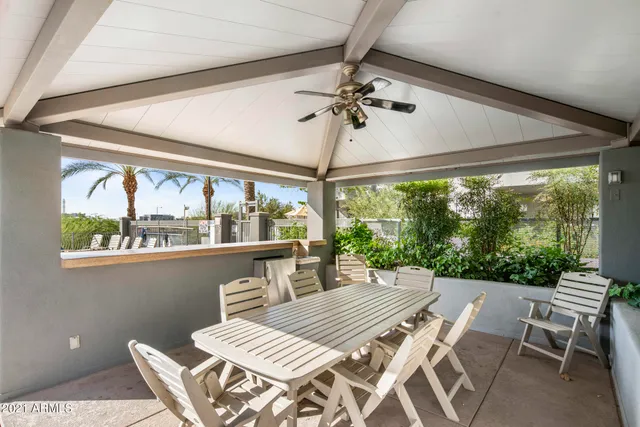 a view of a dining room with furniture a chandelier and large windows