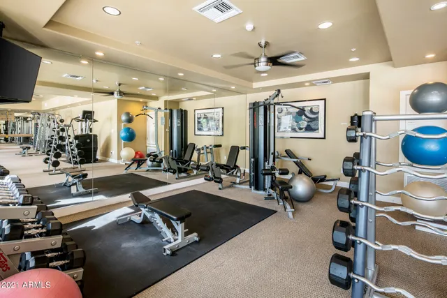 a room with gym equipment and glass windows