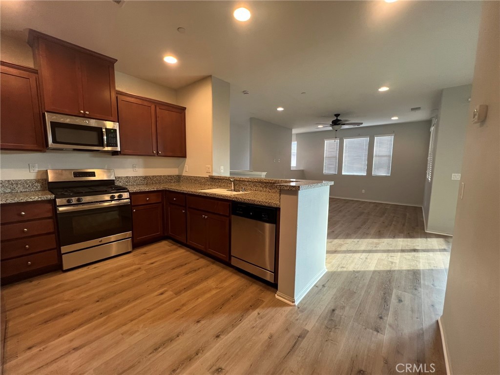 16001 Chase Fontana, CA 92336 - Photo 12 of 14 a kitchen with stainless steel appliances granite countertop a stove a sink and a microwave