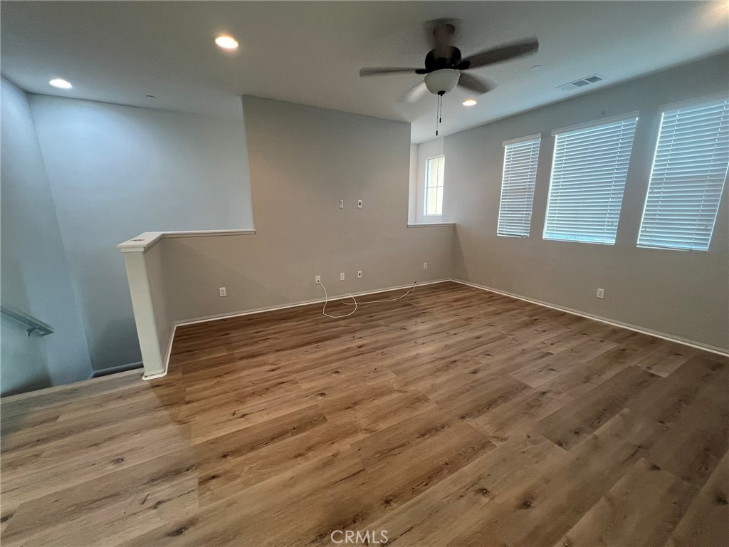 16001 Chase Fontana, CA 92336 - Photo 2 of 14 an empty room with wooden floor and windows