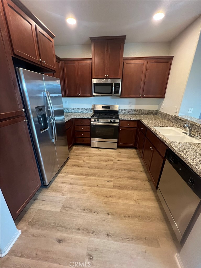 16001 Chase Fontana, CA 92336 - Photo 5 of 14 a kitchen with granite countertop wooden cabinets and a stainless steel appliances