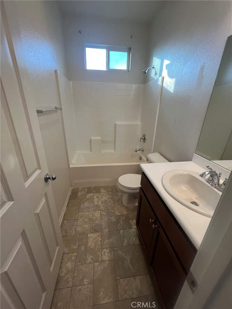 16001 Chase Fontana, CA 92336 - Photo 7 of 14 a bathroom with a sink a toilet a mirror and bathtub