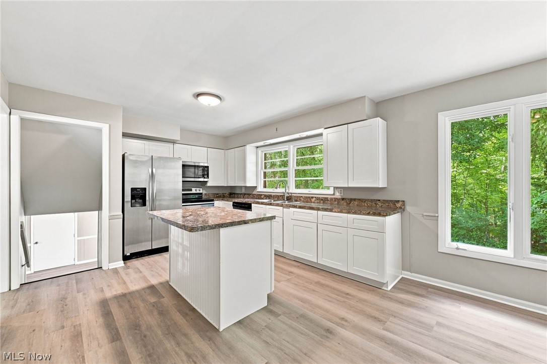 558 Garnette Road Akron, OH 44313 - Photo 6 of 31 Kitchen featuring white cabinetry, stone-finish countertops, stainless steel appliances, and a central island