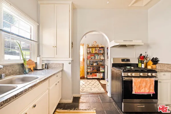 a kitchen with stainless steel appliances granite countertop a stove a sink and a microwave