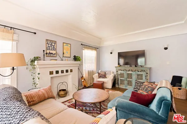 a living room with furniture a flat screen tv and a fireplace